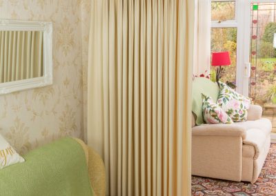 Full length cream curtains on a gold pole