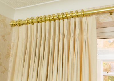Triple pleated curtain on a gold pole