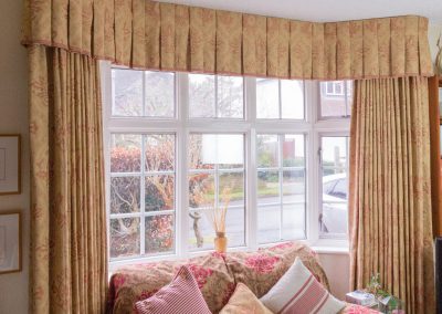 Full length curtains with matching pelmet in a bay window
