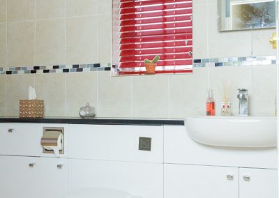 Red metal venetian blind in bathroom