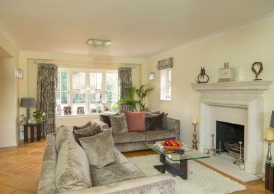 View across a lounge showing full length curtains & roman blind