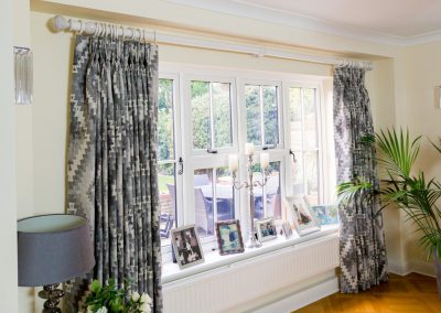 Large window with full length triple pleated curtains pulled back