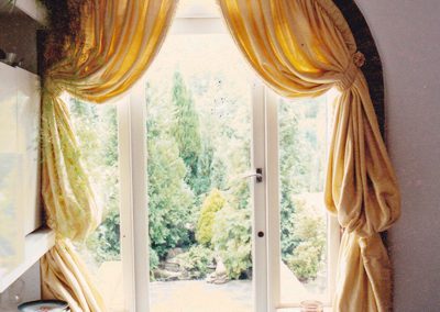 Full length curtains in an arch and tied-back