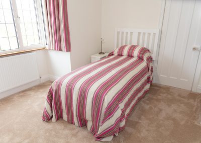 Pink striped bed throw on a single bed