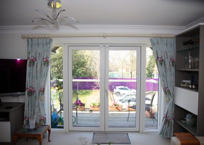 Floor length pleated curtains with ornate hold-backs